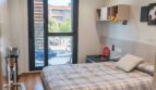 Helles Schlafzimmer mit Doppelbett, Deckenventilator, Parkettboden und Balkonzugang in Palma de Mallorca