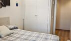 Helles Schlafzimmer mit blau-weißer Bettwäsche, weißem Einbauschrank und Holzboden im Luxus-Apartment Palma