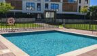 Gemeinschaftspool mit Holzdeck und modernem Wohngebäude in exklusiver Residenz Palma de Mallorca