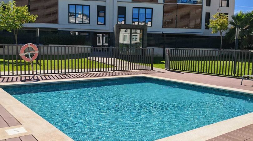 Gemeinschaftspool mit Holzdeck und modernem Wohngebäude in exklusiver Residenz Palma de Mallorca