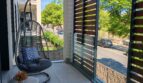 Moderner Balkon mit Hängesessel, Sichtschutz und Blick auf grüne Bäume in luxuriöser Residenz Palma