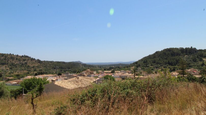Vista panorámica de Mancor de la Vall con pueblo, colinas y vegetación mediterránea en ubicación rural tranquila.