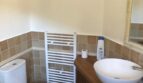Badezimmer der Finca Llucmajor mit Vessel-Waschbecken, Handtuchheizkörper und Holzunterschrank.