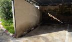 Überdachter Carport Nr. 60 mit Betonboden und Wellblechdach, umgeben von mediterraner Vegetation.