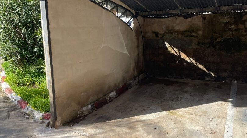 Überdachter Carport Nr. 60 mit Betonboden und Wellblechdach, umgeben von mediterraner Vegetation.