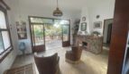 Wohnzimmer der mediterranen Villa mit Kamin, Ledersesseln und Terrassenzugang zum Garten in Porto Cristo.