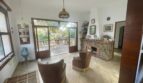 Wohnzimmer der mediterranen Villa mit Kamin, Ledersesseln und Terrassenzugang zum Garten in Porto Cristo