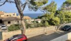 Straße vor mediterraner Villa in Porto Cristo mit Meerblick, Pinien und Natursteinmauern