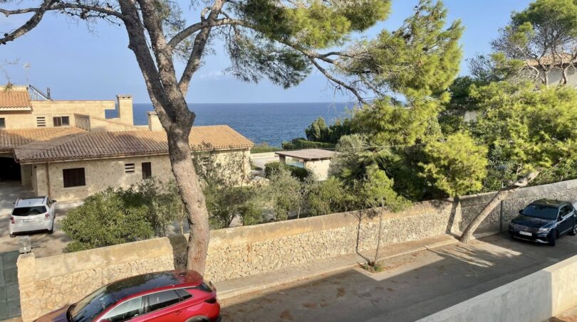 Straße vor mediterraner Villa in Porto Cristo mit Meerblick, Pinien und Natursteinmauern