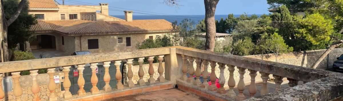 Sunny terrace with stone balustrade and sea view of the Mediterranean villa in Porto Cristo