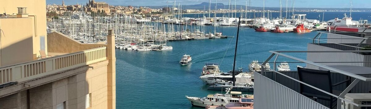 Balkonblick auf den Hafen von Palma mit Yachten, türkisem Wasser und der Kathedrale im Hintergrund
