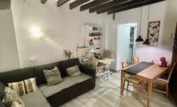 Wohnzimmer der Altstadtwohnung Palma mit Holzbalkendecke, Ecksofa und Esstisch