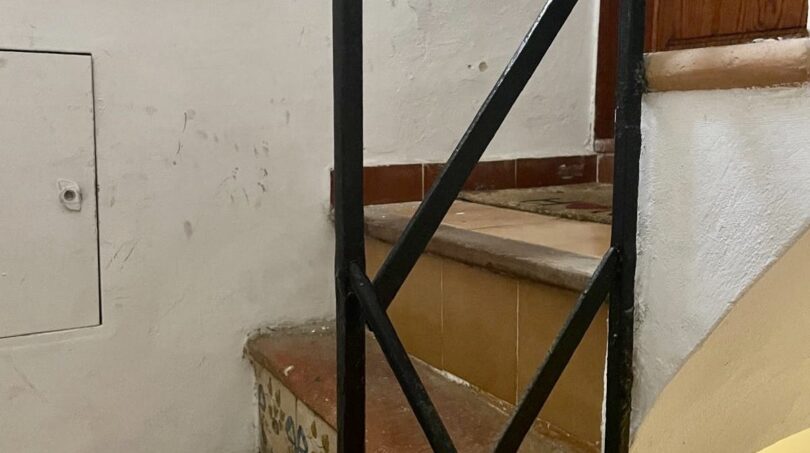 Escalera con barandilla de hierro forjado y peldaños de azulejo decorados en apartamento del casco antiguo de Palma de Mallorca