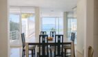 Helles Esszimmer der First-Line-Villa in Llucmajor mit Meerblick, Pool und großen Panoramafenstern.