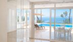 Heller Wohnbereich mit Marmorböden, Glasfront und Blick auf Pool, Terrasse und Meer in Llucmajor-Villa