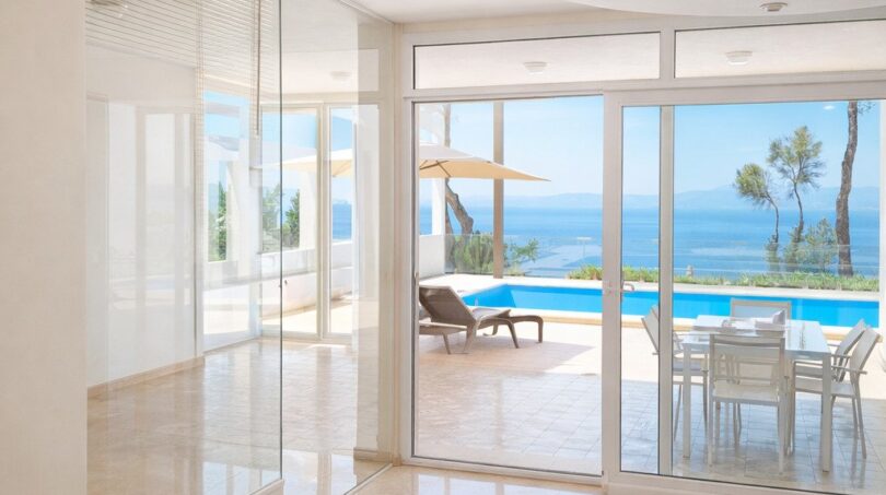 Heller Wohnbereich mit Marmorböden, Glasfront und Blick auf Pool, Terrasse und Meer in Llucmajor-Villa