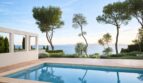 Außenpool der First-Line-Villa in Llucmajor mit direktem Meerblick, mediterranen Pinien und weißer Pergola.
