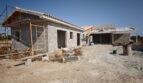 Estructura en bruto de una finca moderna en Vilafranca de Bonany con andamios, bloques de hormigón y techo de tejas mediterráneo.
