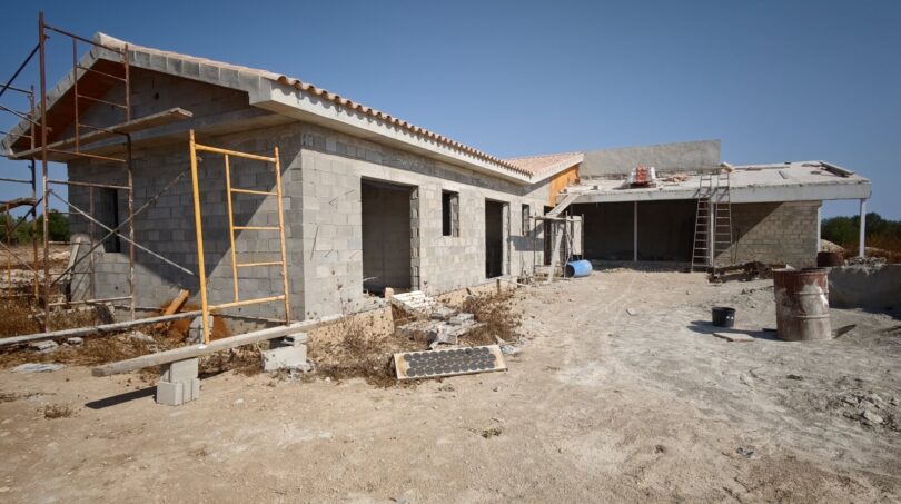 Estructura en bruto de una finca moderna en Vilafranca de Bonany con andamios, bloques de hormigón y techo de tejas mediterráneo.
