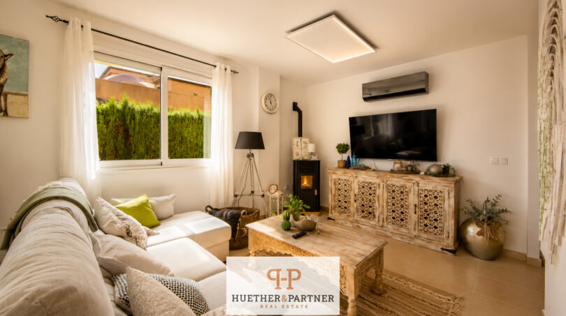 Helles Wohnzimmer des Luxus-Chalets in Cala Murada mit Kamin, TV-Sideboard und gemütlicher Sofaecke