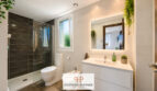 Modernes Badezimmer im Luxus-Chalet Cala Murada mit Dusche, Doppelwaschtisch, Bidet und Grünpflanzen.