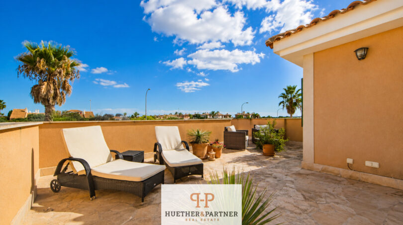 Sonnige Dachterrasse mit Liegestühlen, Palmen und weitem Ausblick des Luxus-Chalets in Cala Murada