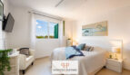 Helles Schlafzimmer im Luxus-Chalet Cala Murada mit Doppelbett, Wandgemälde und Meerblick-Fenster.