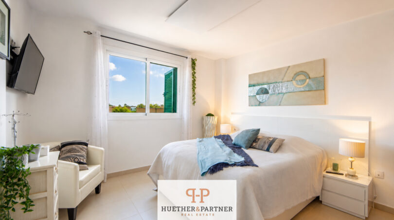 Helles Schlafzimmer im Luxus-Chalet Cala Murada mit Doppelbett, Wandgemälde und Meerblick-Fenster.