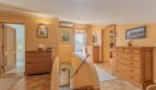 Heller Treppenbereich der Finca in Campanet mit Holzkommoden, Klimaanlage und Zugang zu mehreren Räumen.