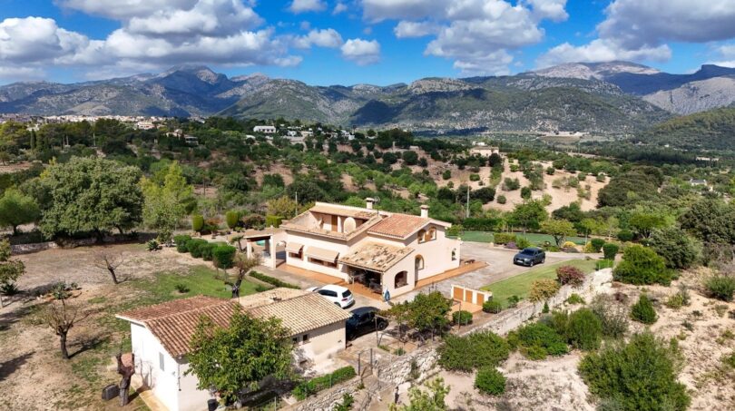 Luftaufnahme einer mediterranen Finca in Campanet mit Terrakottadach, Garten und Bergpanorama der Serra de Tramuntana