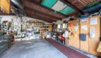 Geräumige Garage der Finca in Campanet mit Holzdecke, Werkzeugwand, Regalen und Abstellflächen.
