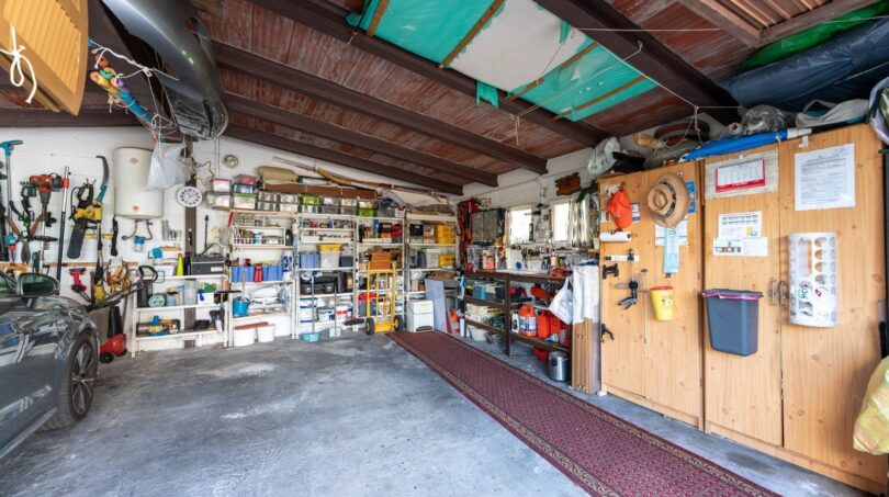 Geräumige Garage der Finca in Campanet mit Holzdecke, Werkzeugwand, Regalen und Abstellflächen.