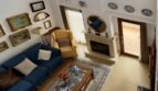 Sala de estar luminosa con techo alto, sofás azules, chimenea y tragaluces en la casa adosada Palma de Mallorca