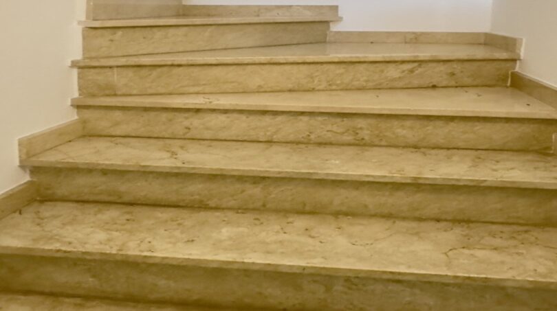 Escultura de escalera con acabado natural y barandilla de metal - Punto culminante arquitectónico con conexión de espacio abierto