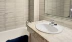 Baño moderno con ducha a ras de suelo y lavabo de mármol - Equipamiento sanitario de alta calidad y área de ducha sin escalón