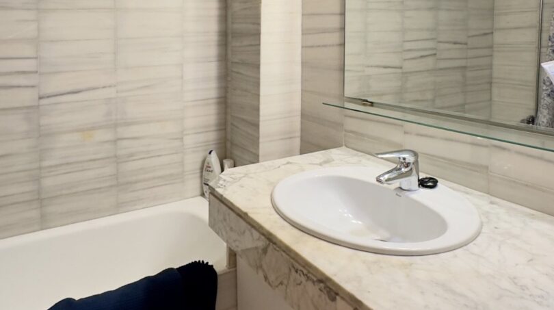 Baño moderno con ducha a ras de suelo y lavabo de mármol - Equipamiento sanitario de alta calidad y área de ducha sin escalón