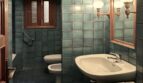 Badezimmer des Chalets mit türkisen Wandfliesen, Waschtisch, Bidet und Wandleuchten in Palmanyola