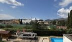 Außenbereich des Chalets in Palmanyola mit blauem Pool, Grillpavillon und Blick auf Tennisplätze und Berge