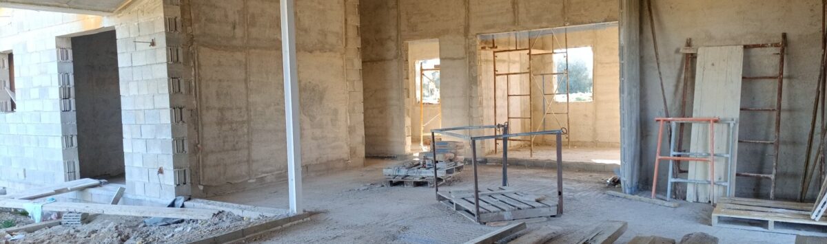 Área interior de estructura bruta de la finca en Vilafranca de Bonany con techo de madera, paredes de hormigón y materiales de construcción.
