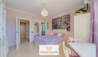 Helles Studio-Schlafzimmer in Cales de Mallorca mit Doppelbett, rosa Wänden und modernem Stadtbild-Wandbild.