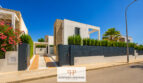 Moderne Bauhausvilla in Cala Murada mit Natursteinakzenten, Einfahrtstor und gepflegtem Gartenbereich.