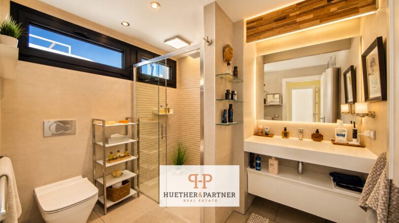 Modernes Badezimmer der Luxusvilla in Cala Murada mit Glasdusche, beleuchtetem Spiegel und hochwertiger Ausstattung.
