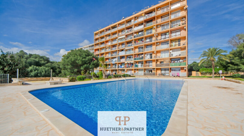 Außenansicht: Mehrgeschössiges Apartmentgebäude in Cales de Mallorca mit großem Gemeinschaftspool und Palmen