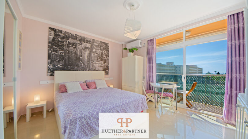 Helles Studio-Schlafzimmer in Cales de Mallorca mit Doppelbett, lila Dekoration und Balkon mit Meerblick
