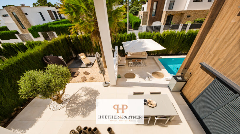 Luftblick auf Terrasse, Pool und Garten der Luxusvilla in Cala Murada mit Lounge und mediterraner Bepflanzung.