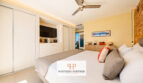 Helles Schlafzimmer der Luxusvilla in Cala Murada mit Doppelbett, Einbauschränken, TV und Meerblick durch Balkontür.