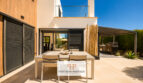 Moderne Außenterrasse der Luxusvilla in Cala Murada mit Esstisch, Pergola, Außenküche und elegantem Loungebereich.