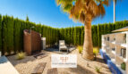 Privater Garten der Luxusvilla in Cala Murada mit Palme, Outdoor-Dusche, Liege und Naturstein-Bepflanzung.