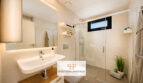 Modernes Badezimmer der Luxusvilla in Cala Murada mit Glasdusche, beleuchtetem Spiegel und hochwertiger Ausstattung.