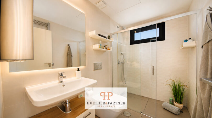 Modernes Badezimmer der Luxusvilla in Cala Murada mit Glasdusche, beleuchtetem Spiegel und hochwertiger Ausstattung.